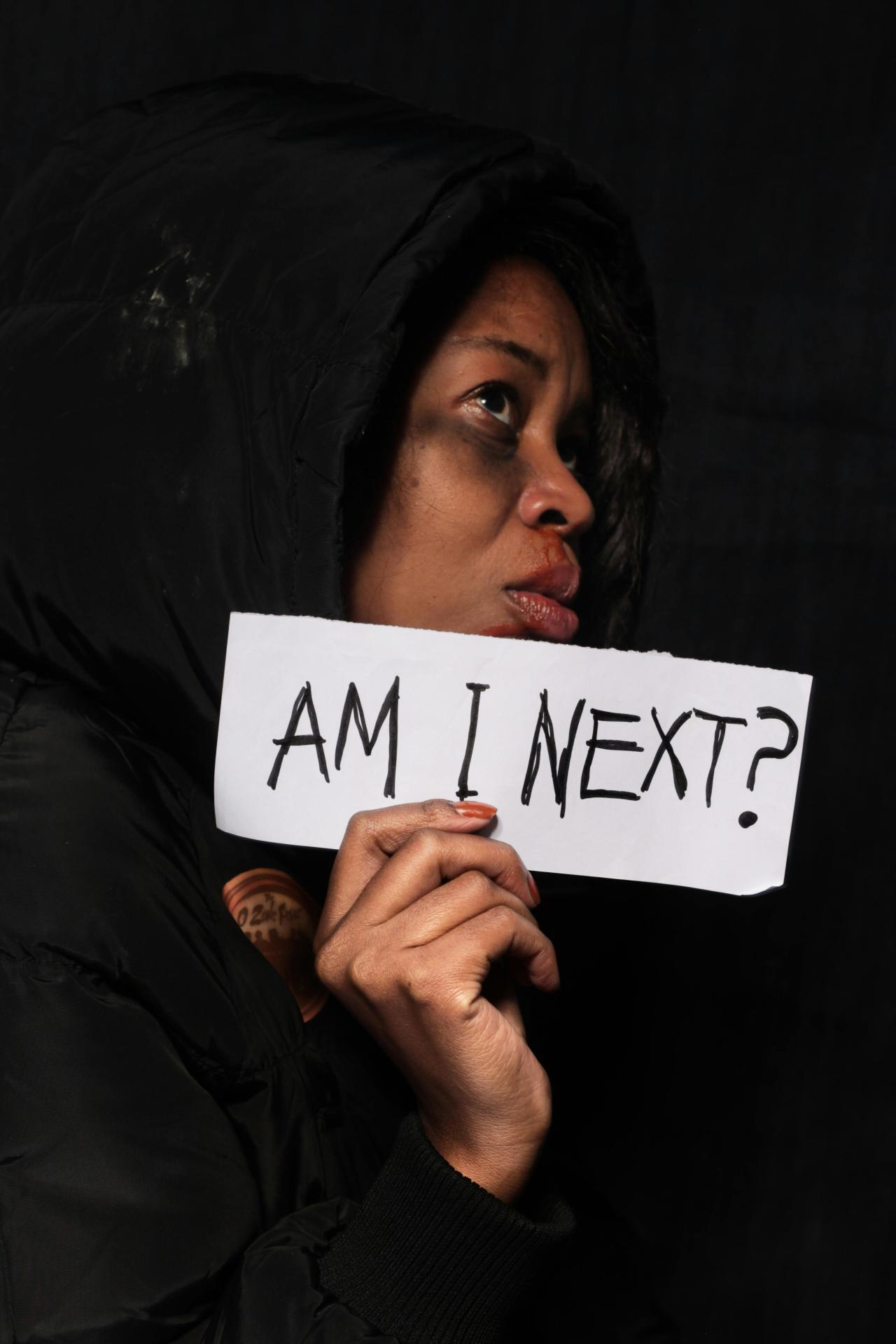 Image of bruised woman holding up a sign courtetsy of Musa Artful from Pexels